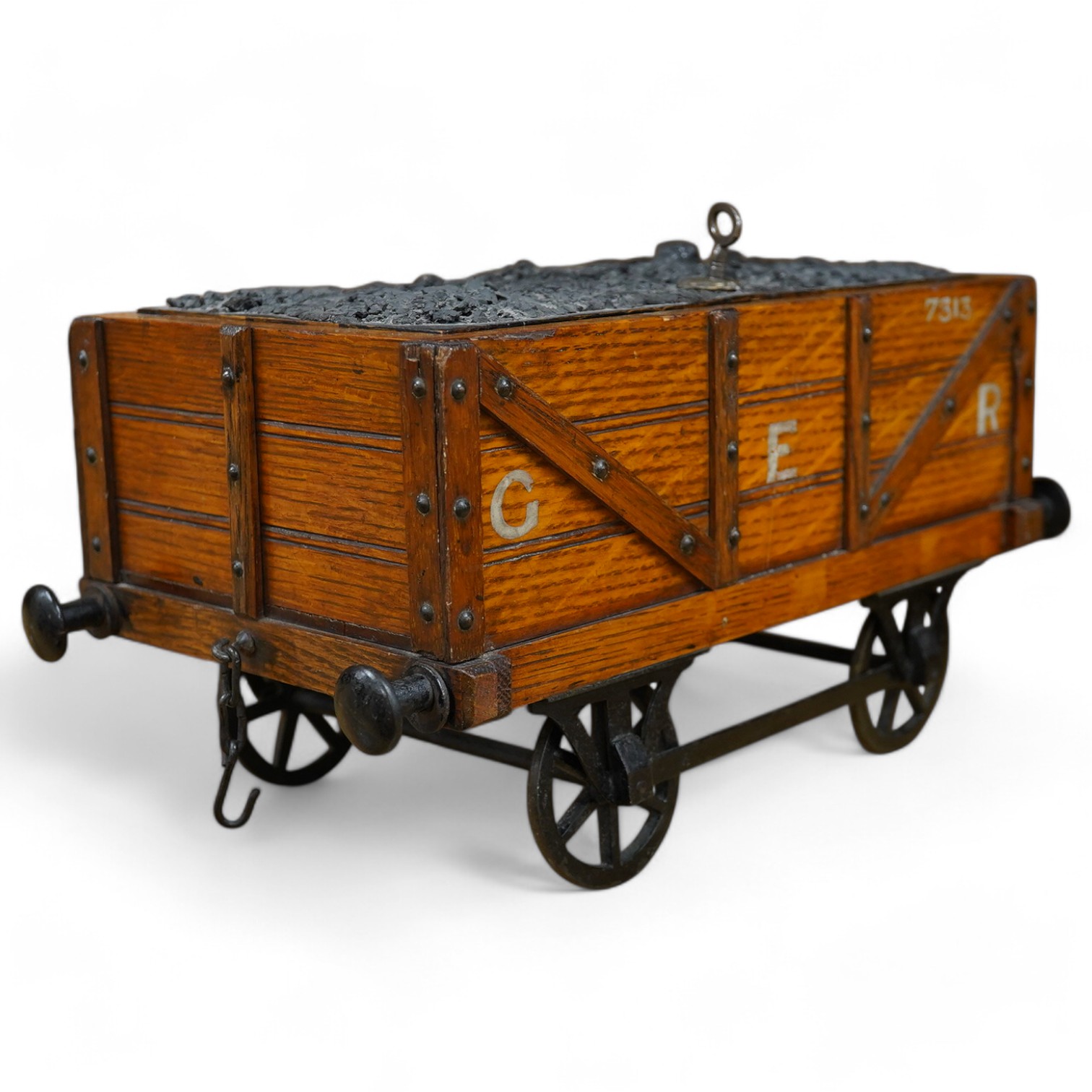 A late 19th or early 20th century novelty cigar box in the form of a railway coal wagon in Great Eastern Railway livery, of oak construction with sectioned interior, integrated match striker, and dummy coal load hiding t